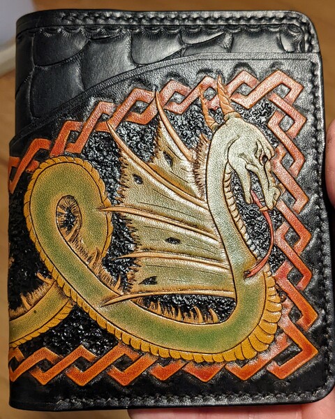 An indoor shot of the hand tooled winged dragon on the front of the wallet.